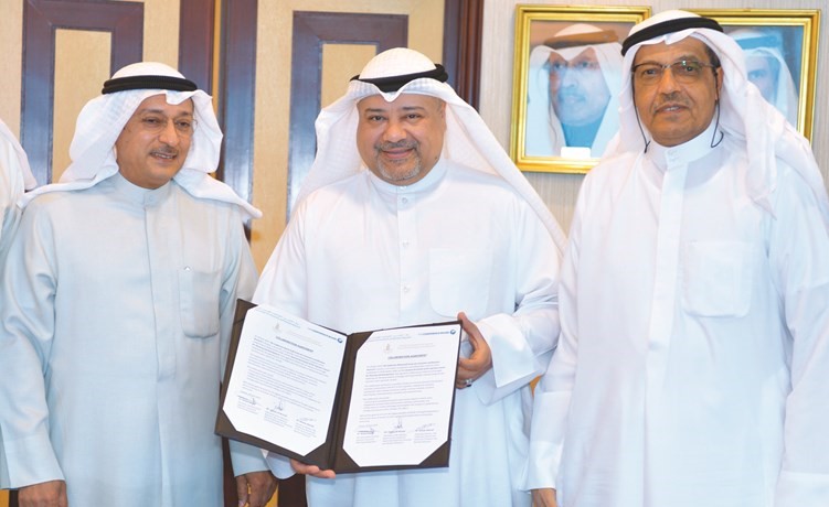 خالد مهدي متوسطا هشام الرزوقي ومهدي الجزاف خلال توقيع الاتفاقية﻿