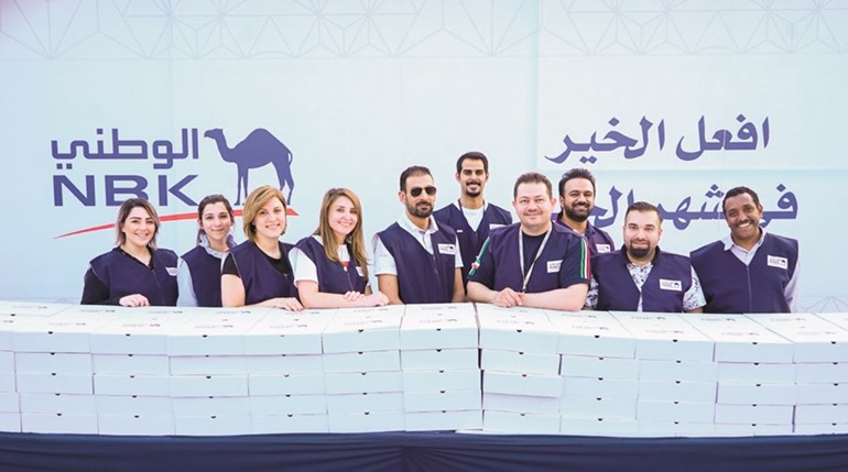 متطوعو بنك الكويت الوطني خلال زيارتهم قصر نايف لتوزيع الوجبات﻿