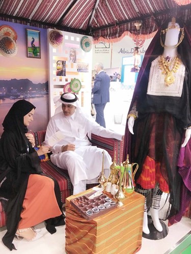 إيمان السلطي أم عفراء تقدم القهوة والحلوى لضيوف جناح عمان﻿