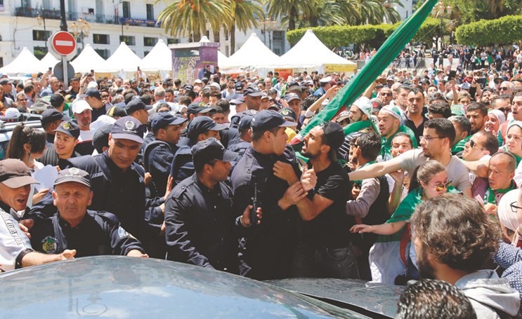 اشتباك بين احد الطلبة وعنصر من الشرطة الجزائرية خلال تظاهرات في العاصمة امس الاول(رويترز) ﻿