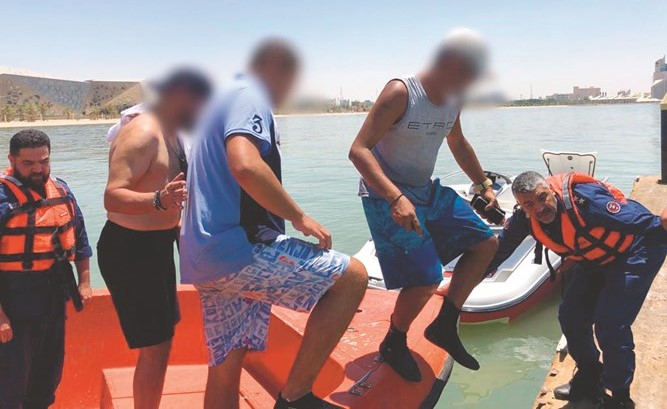 رجال الإنقاذ البحري خلال عملية تسليم العالقين للطوارئ الطبية﻿