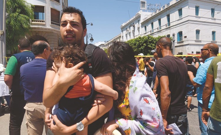 مدنيون تونسيون في موقع الهجوم الانتحاري في جادة الحبيب بورقيبة	(أ.ف.پ)﻿