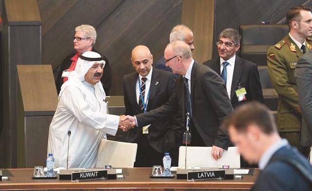 الشيخ ناصر صباح الأحمد مصافحا أحد المشاركين في اجتماع وزراء الدفاع للدول الأعضاء في التحالف الدولي لمحاربة داعش﻿