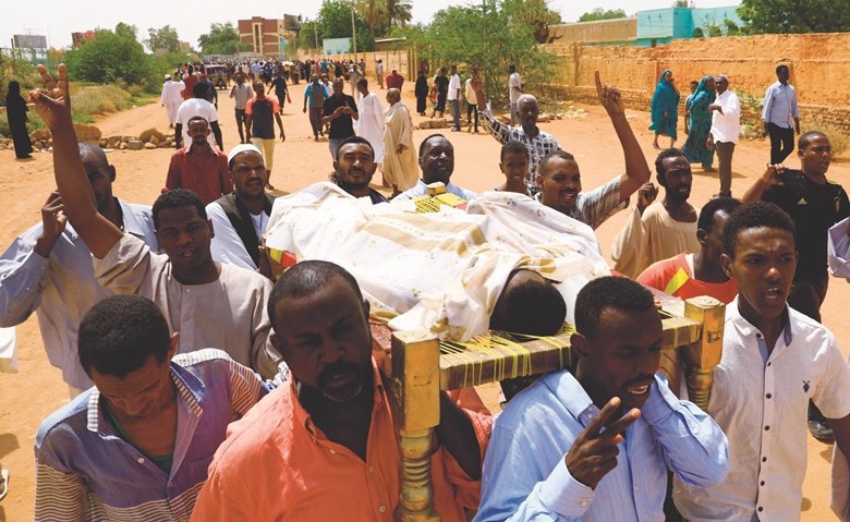 سودانيون يحملون جثمان أحد القتلى الثلاثة في أم درمان امس	 (رويترز)﻿