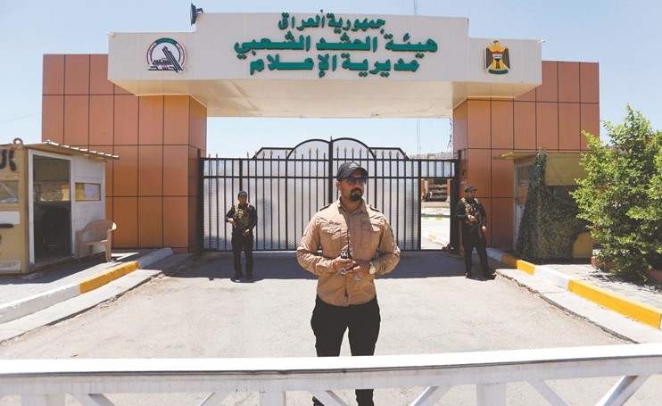 أعضاء من قوات الحشد الشعبي يقفون حرسا امام المركز الإعلامي لقوات الحشد في بغداد امس 	(رويترز)﻿