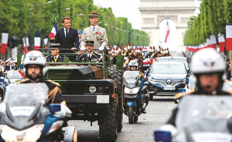 الرئيس الفرنسي إيمانويل ماكرون ورئيس أركان الجيش الفرنسي فرانسوا ليكوينتر خلال العرض العسكري بمناسبة يوم الباستيل في باريس أمس					 (أ.ف.پ)﻿