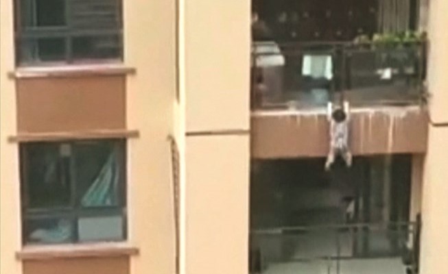 الطفل متشبثا بحافة الشرفة﻿