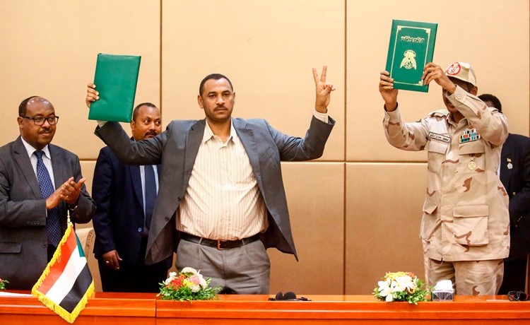 احد قادة المعارضة السودانية أحمد ربيع ونائب رئيس المجلس العسكري الانتقالي محمد حمدان دقلو بعد التوقيع على الإعلان الدستوري في الخرطوم امس(أ.ف.پ)﻿