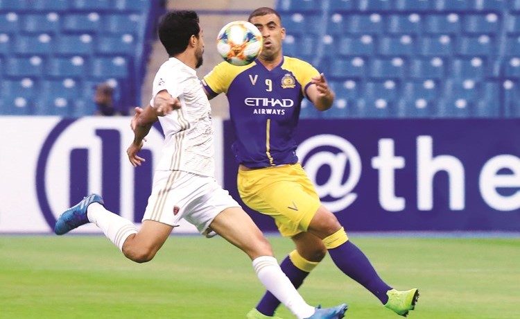 مهاجم النصر عبدالرزاق حمدالله يحاول المرور من مدافع الوحدة حمدان الكمالي	 (أ.ف.پ)﻿