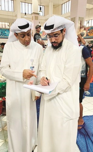 علي الأربش وإسماعيل الغرير خلال عملية مراقبة سوق السمك ﻿