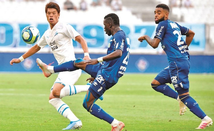 لاعب رينس موسى دومبيا يروض الكرة تحت انظار لاعب مارسليا هيروكي ساكاي	 (أ.ف.پ) ﻿