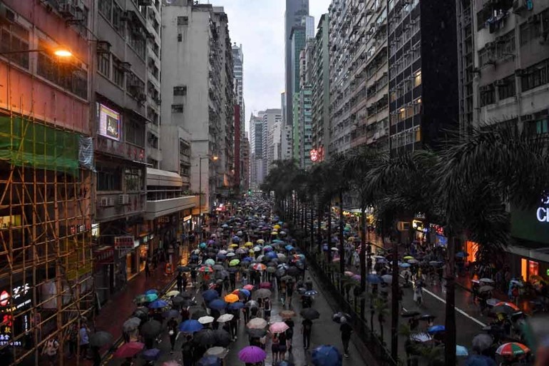 متظاهرو هونغ كونغ ينظمون مسيرة وسط الرياح والأمطار الغزيرة