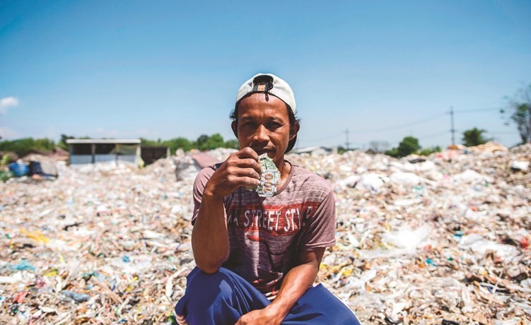  ﻿كيمان محاطا بالنفايات البلاستيكية ﻿﻿في قرية بانغون	(أ.ف.پ)﻿