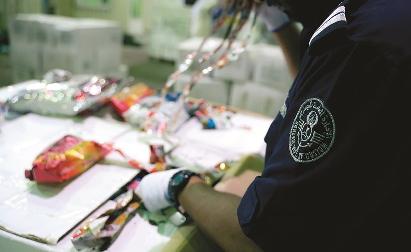 احد رجال جمارك ميناء الشويخ خلال استخراج المضبوطات﻿