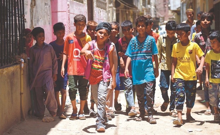 الطفل وقاص بالوش يرقص الراب أمام عدد من الاطفال في حي لياري﻿