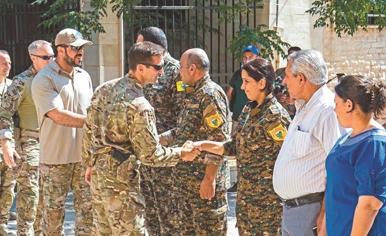 عسكريون من التحالف ضد داعش الذي تقوده واشنطن يجتمعون مع عناصر من القوات المحلية الكردية التابعة للمجلس العسكري لتل ابيض	(أ.ف.پ)﻿