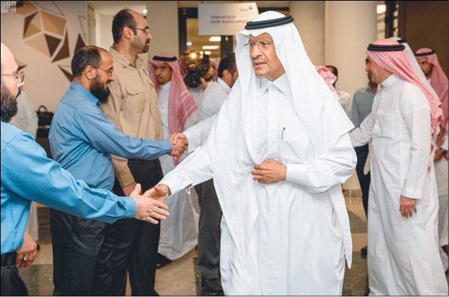 صاحب السمو الملكي الأمير عبدالعزيز بن سلمان يصافح الموظفين أثناء زيارته لمعامل «ارامكو» النفطية (رويترز)