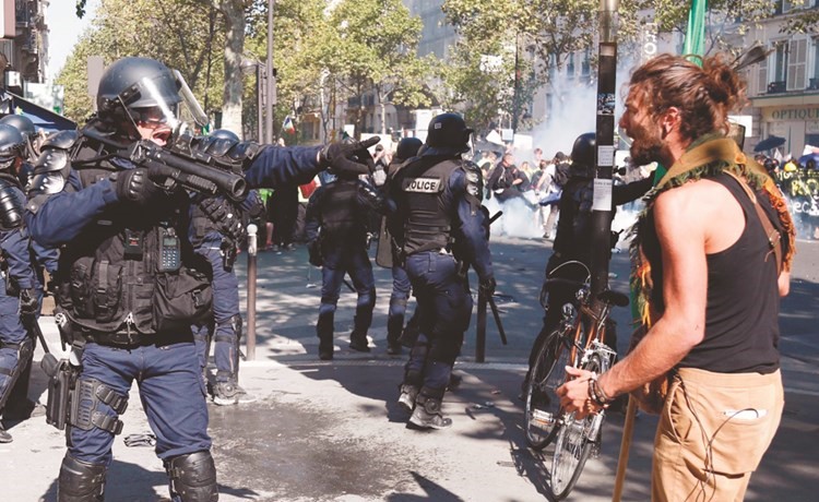  محتج يواجه الشرطة خلال احتجاجات باريس امس	(أ.ف.پ)﻿
