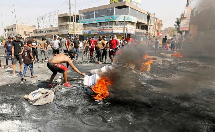 محتجون يشعلون إطارات خلال اليوم الثالث للتظاهرات في بغداد امس	(رويترز)﻿
