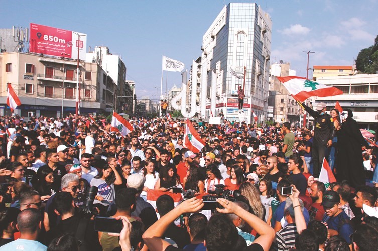 آلاف المتظاهرين يحملون الأعلام اللبنانية خلال الاحتجاجات في طرابلس امس	(رويترز)﻿