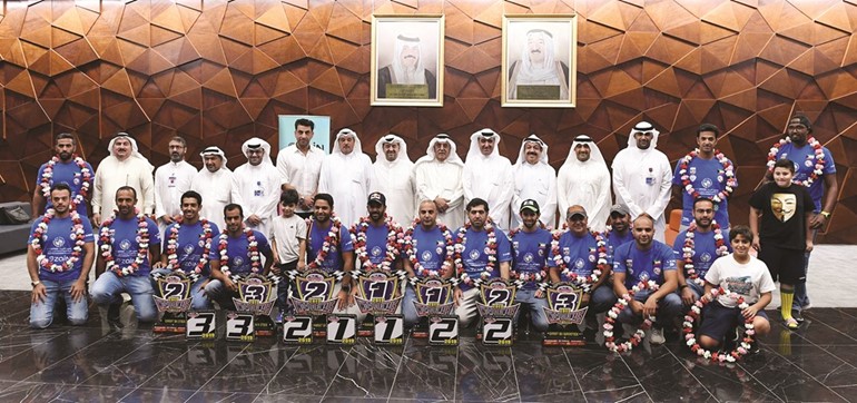الفهد والخشتي يتوسطان أبطال المنتخب ومسؤولو النادي البحري وفريق زين في مطار الكويت الدولي ﻿