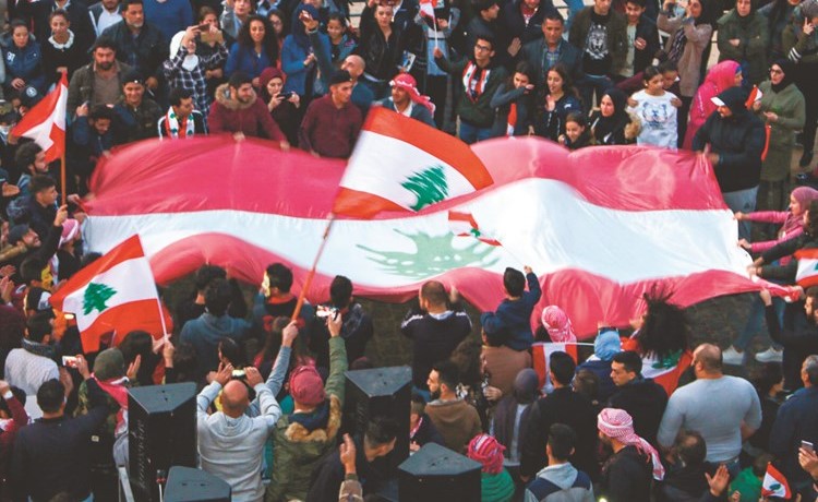 محتجون يلوحون بالأعلام الوطنية خلال تظاهرهم في بعلبك أمس	(أ.ف.پ)﻿