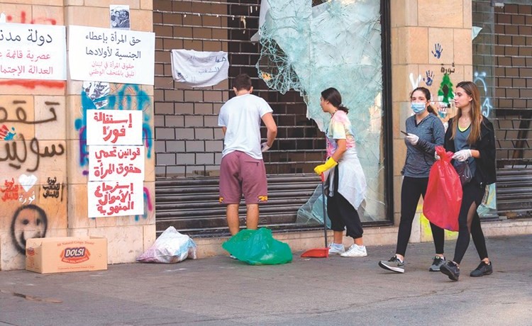 شباب يقومون بتنظيف الساحات والشعارات تملأ الجدران 	(محمود الطويل)﻿