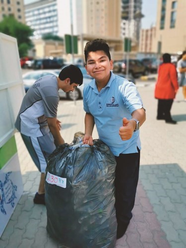 أحد الطلبة مشاركا في الحملة البيئية﻿