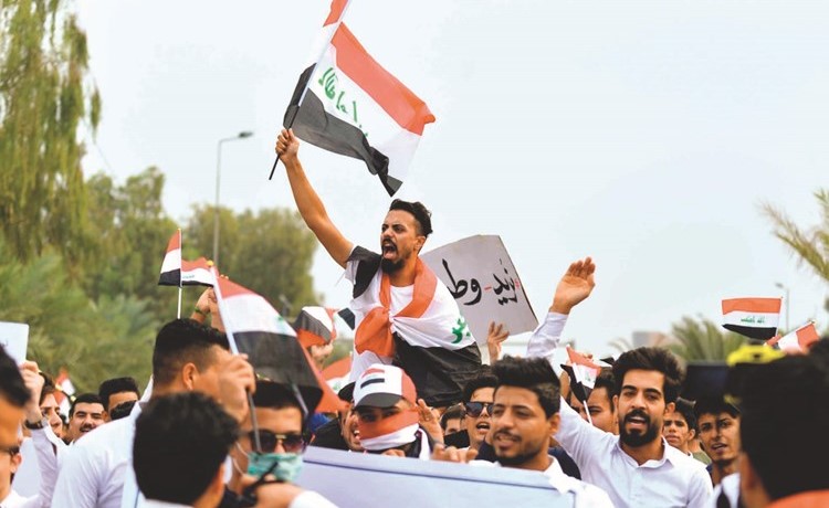 طلاب يلوحون بالعلم الوطني ويهتفون من اجل التغيير خلال احتجاجات بالنجف امس	(ا.ف.پ) ﻿