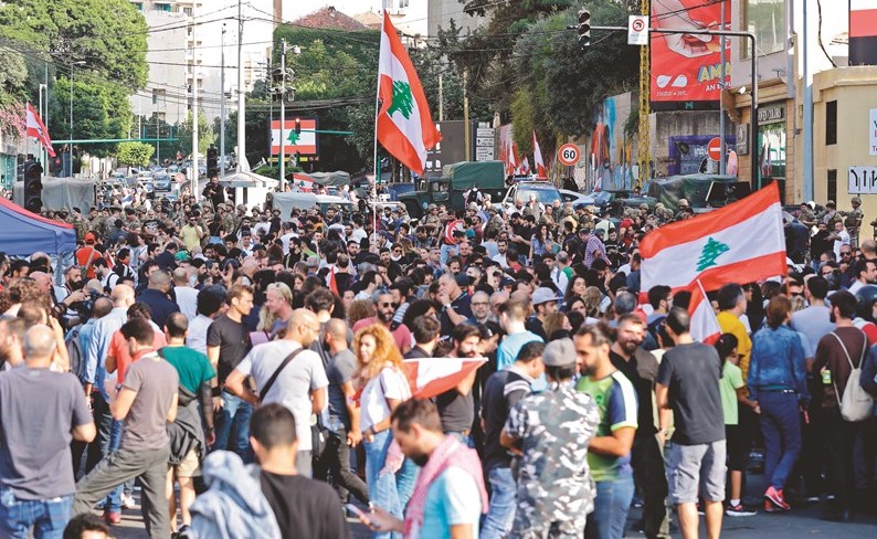المحتجون يعودون الى الشوارع رافعين العلم فرحا بإعلان استقالة الحكومة	(أ.ف.پ)﻿