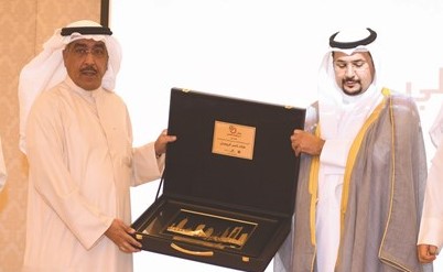 عدنان الراشد مسلما درعا تكريمية لممثل راعي الحفل محمد العدواني﻿