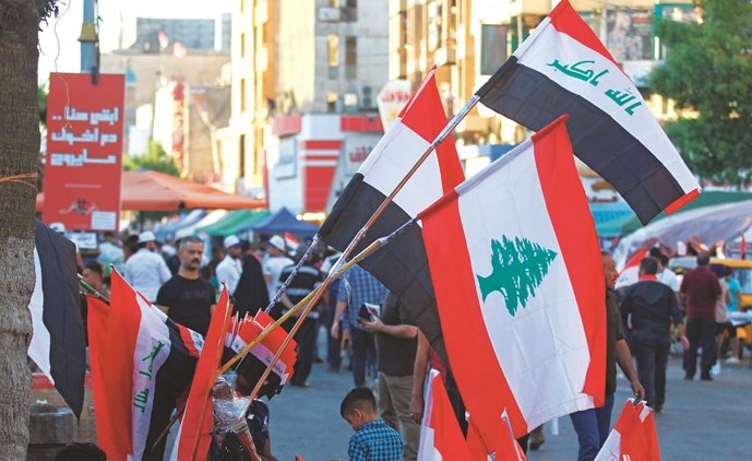 أعلام عراقية ولبنانية تباع جنبا إلى جنب في أحد المحلات في بغداد 	(أ.ف.پ)﻿