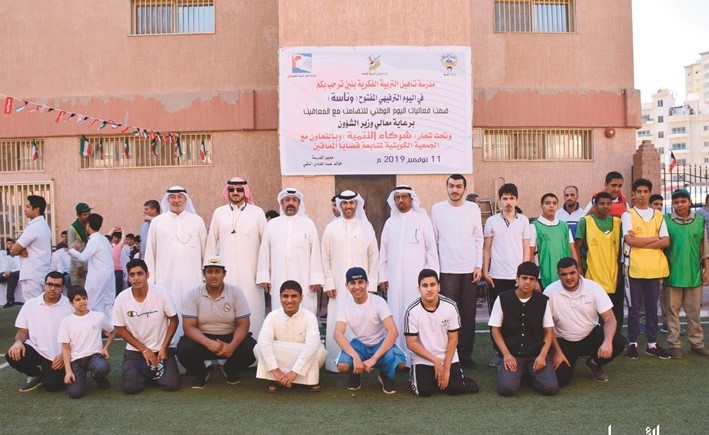 علي البغلي مدير أول الاتصالات والعلاقات الخارجية بالبنك الأهلي يتوسط مدير المدرسة خالد النقي وعلي ثويني أمين سر الجمعية مع عدد من الطلبة﻿