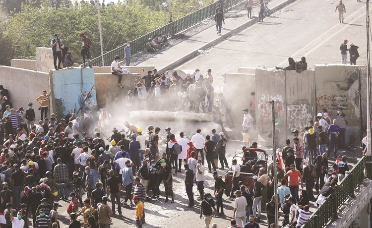 المتظاهرون يحطمون الجدران الخرسانية عند جسر السنك					(رويترز)﻿