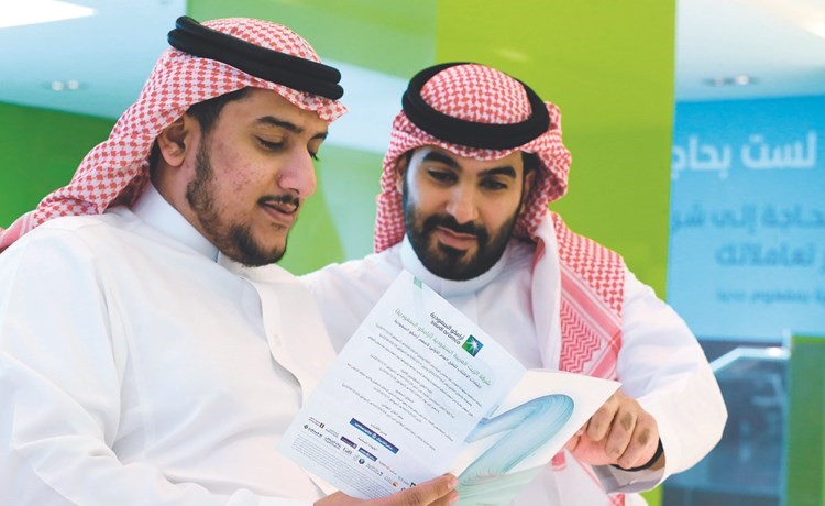 مستثمران سعوديان يراجعون نشرة الاكتتاب العام في أرامكو في الرياض	(رويترز) ﻿