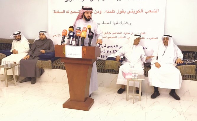د.عادل الدمخي متحدثا ويبدو أسامة الشاهين والمشاركين في الندوة﻿