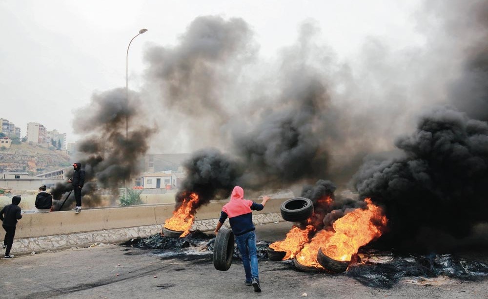 محتجون لبنانيون يحرقون الاطارات لقطع الطريق المؤدي الى مدينة طرابلس        (ا.ف.پ)
