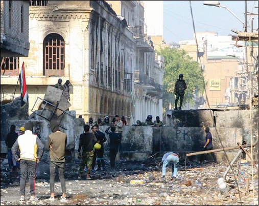 محتجون عراقيون في مواجهة القوات الأمنية في شارع الرشيد ببغداد أمس   (أ.ف.پ)
