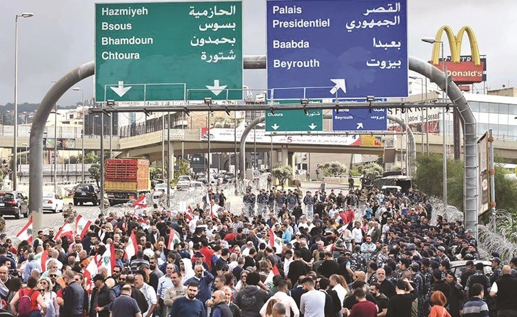 محتجون من الحراك المدني خلال تظاهرة على طريق القصر الجمهوري مقابل تظاهرة اخرى للتيار الوطني الحر وقوى مكافحة الشغب والجيش تفصل بين التظاهرتين(محمود الطويل)﻿