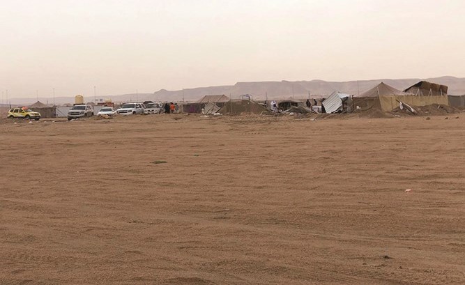 المخيم خلال مراحل إزالته وتبدو آليات من بلدية الكويت تشرف على مساوته بالأرض﻿