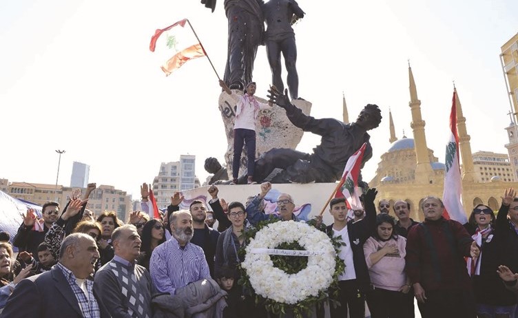 محتجون من حراك بوسطة الثورة في ساحة الشهداء في وسط بيروت حيث وضعوااكليلا من الزهور على تمثال الشهداء 	(محمود الطويل)﻿