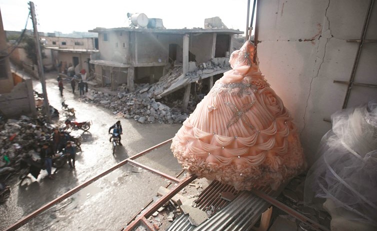 فستان عرس في واجهة محل مدمر نتيجة الغارات في بلدة بليون بريف ادلب امس	(أ.ف.پ)﻿