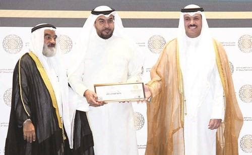 د.محمد الهاشل يسلم التكريم إلى د.أنور المضف خلال المؤتمر