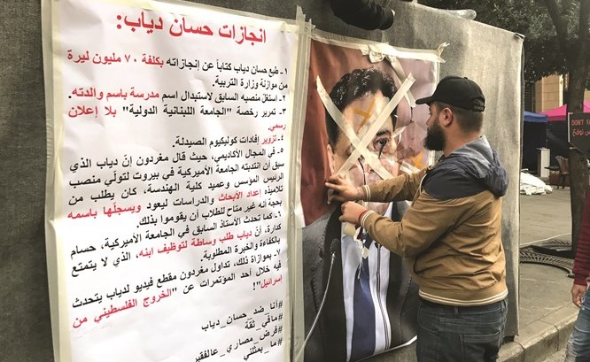 شبان من الحراك الشعبي يتلفون صورة رئيس الحكومة المكلف د. حسان دياب في ساحة رياض الصلح بوسط بيروت	(محمود الطويل)