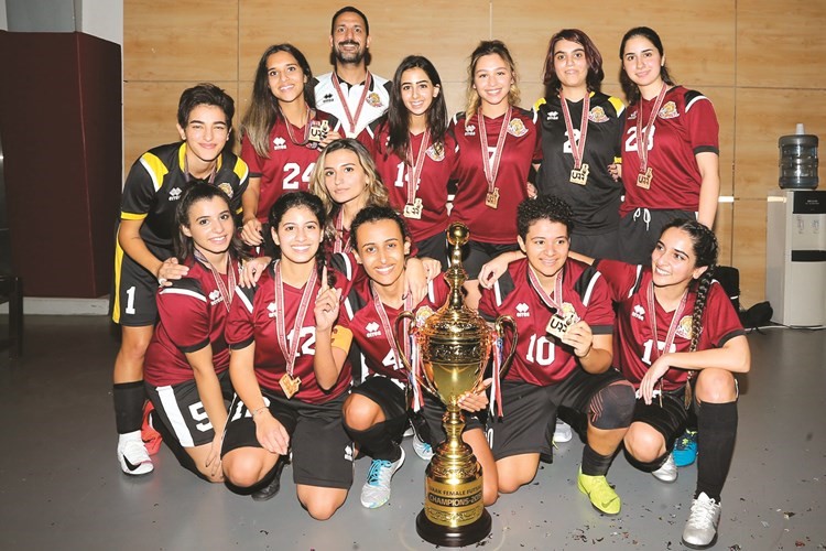 لقطة جماعية لفريق كرة الصالات للسيدات في الجامعة الأمريكية لكرة القدم مع مدربهن