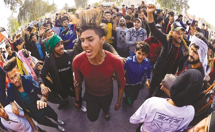 محتجون يشيعون الناشط ثائر الطيب في النجف أمس	(أ.ف.پ)