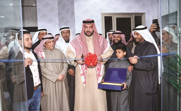 الشيخ مبارك العبدالله خلال قص شريط افتتاح المكتبة بحضور عبدالله فهاد ومحمد الثنيان