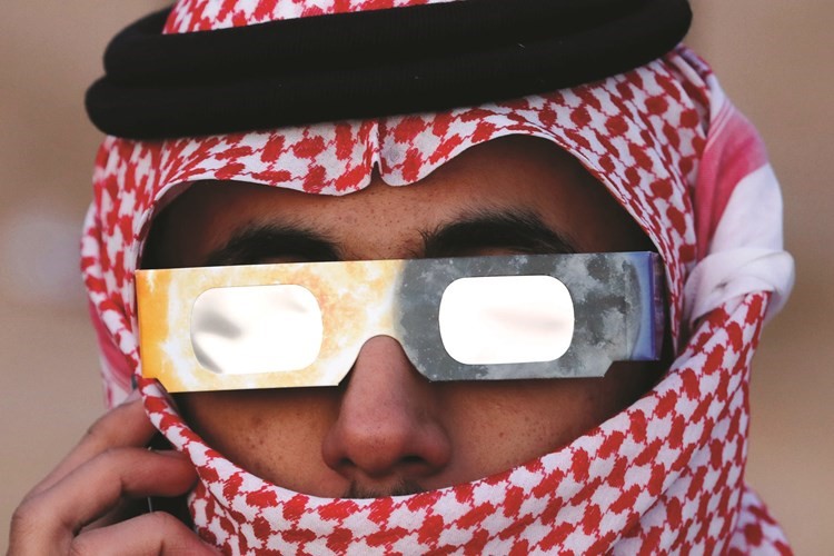 سعودي يتابع الكسوف بنظارة خاصة	(رويترز)
