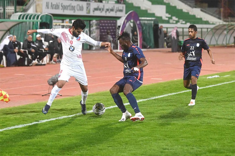 لاعب الكويت فيصل زايد يحاول المرور من محترف اليرموك سينامي دوف (محمد هاشم)