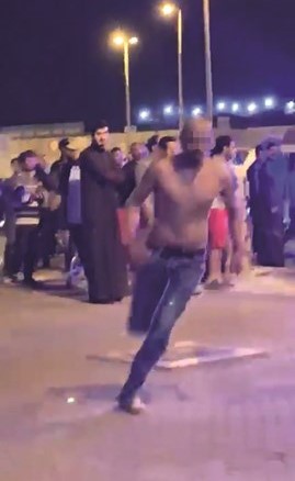 المشتبه به في سرقة مركبات وهو يعتلي الدورية عاري الصدر قبل ان ينزل منها ويفر هاربا